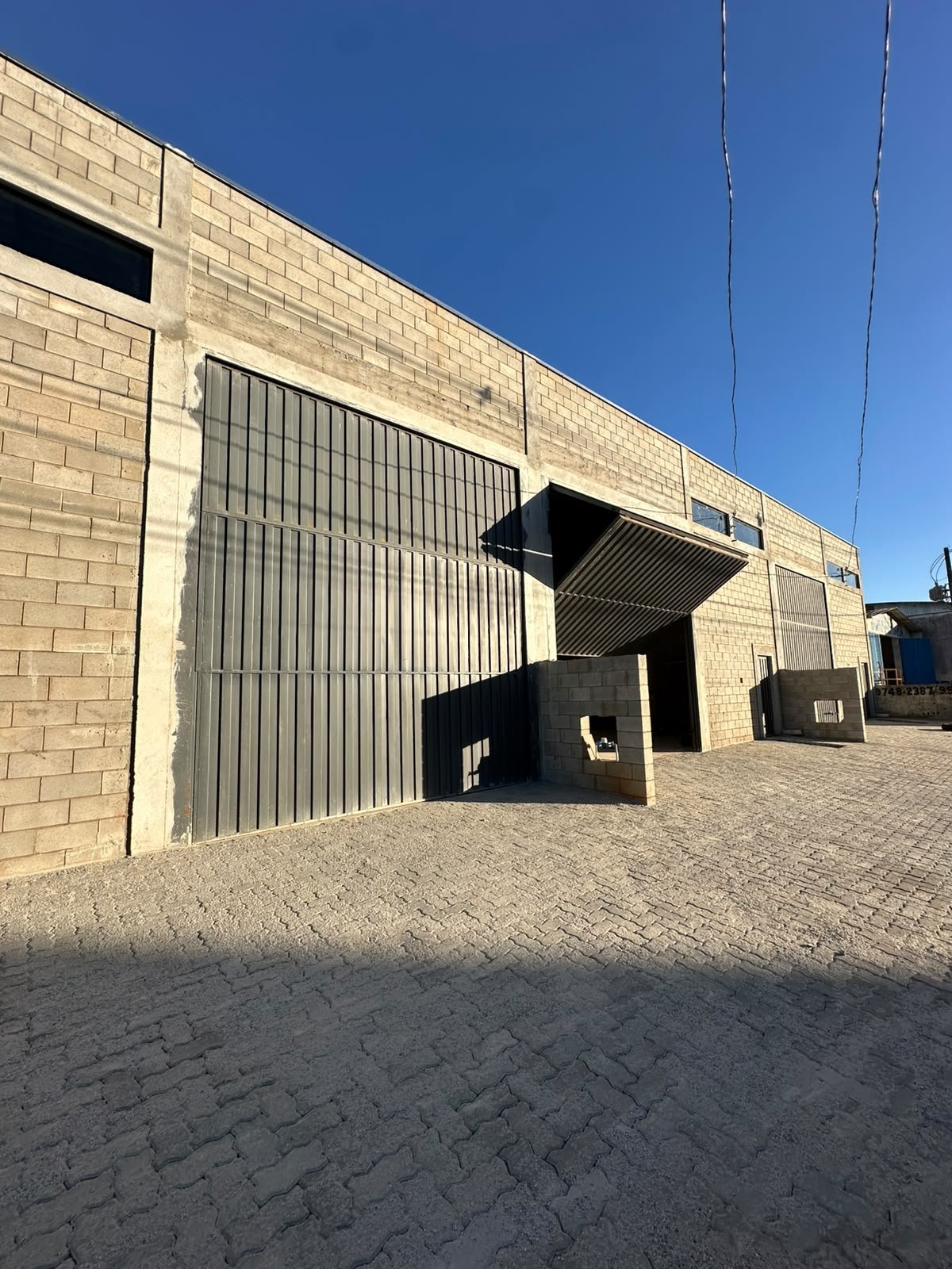 Fachada do galpão comercial com pátio calçado