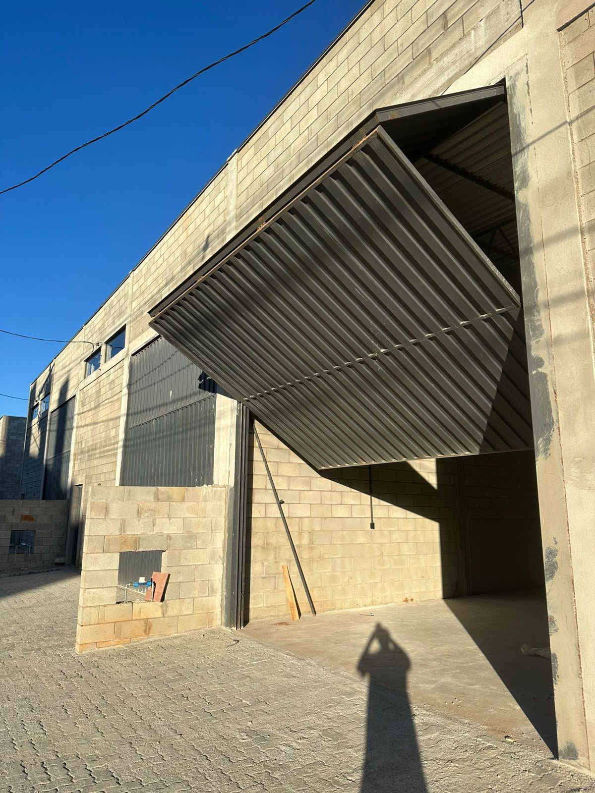 Pátio calçado em frente ao galpão, com espaço para manobra